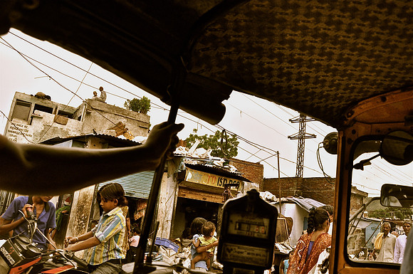 Auto Rickshaw Driving Past a Slum