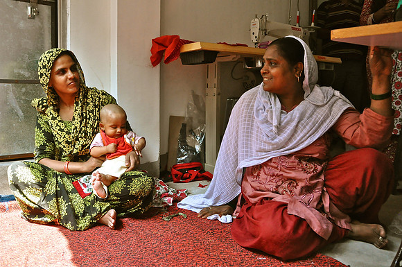 Moslem Women Sewing Clothes with Baby